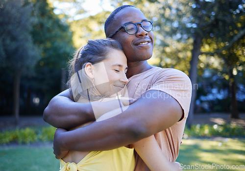 Image of Black man, interracial couple and hug on park lawn with love, care and bonding for quality time, reunion and happiness. Multicultural embrace, happy relationship and outdoor diversity on adventure