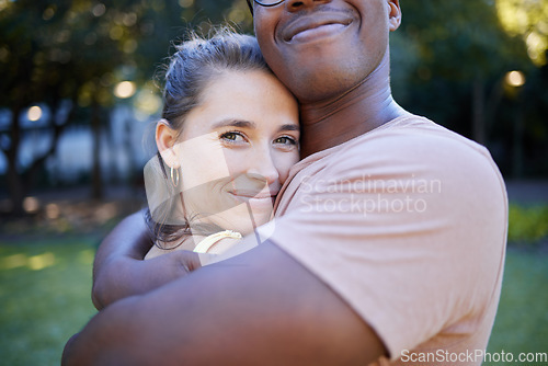 Image of Interracial relationship hug, park and woman with smile, care and love with black man, reunion and happiness. Multicultural embrace, happy couple and diversity on nature adventure, bonding and spring