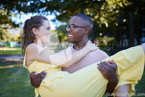 Image of Love, park and carrying with an interracial couple bonding outdoor together on a romantic date in nature. Summer, romance and diversity with a man and woman dating outside in a green garden