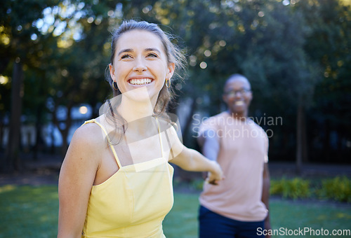 Image of Interracial, couple holding hands and park with happiness, romance and bonding outdoor, love or relationship. Romantic, woman and black man in nature, joyful or touching hand on date and quality time