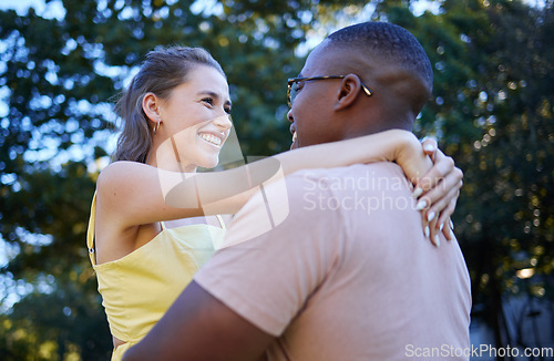 Image of Interracial couple, smile and hug in romance for love, care or embracing relationship in a nature park. Happy black man hugging woman and smiling in happiness for romantic, embrace or support outside