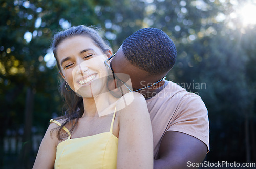 Image of Love, park and kissing with an interracial couple bonding outdoor together on a romantic date in nature. Summer, romance and diversity with a man and woman dating outside in a green garden