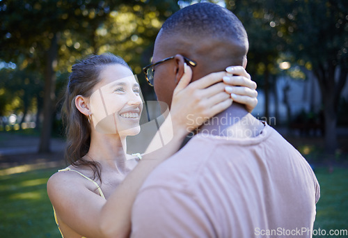 Image of Love, park and smile with an interracial couple bonding outdoor together on a romantic date in nature. Summer, romance and diversity with a man and woman dating outside in a green garden