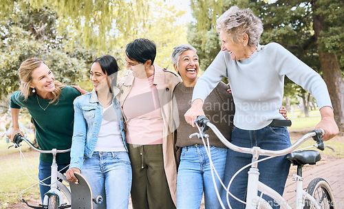 Image of Senior people, friends and laughing on bike in joyful happiness enjoying fun time together at the park. Group of elderly women bonding and sharing joke, laugh or walking and cycling in the outdoors