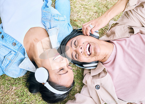 Image of Face, friends and happy with women and headphones, listening to music outdoor with podcast and technology. Happiness top view, radio and audio streaming in park with people together and wellness