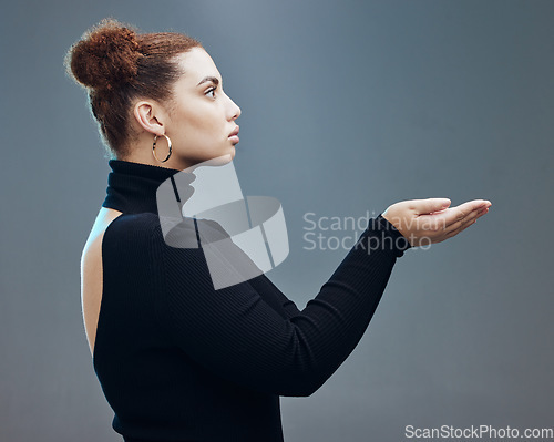 Image of Hand, woman and holding gesture in studio with mockup, space and grey background for product placement. Young, beautiful and girl with open palm hands on mock up, branding and showing copy space
