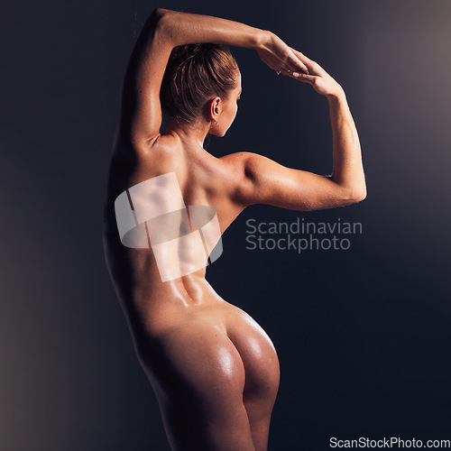 Image of Body, beauty and nude with a model woman posing sexy or seductive in studio on a dark background. Art, naked and sensual with an attractive young female standing to promote erotic or sexual freedom