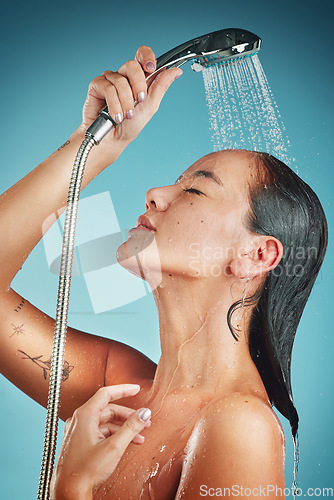 Image of Cleaning, water and shower, woman with hygiene and body care, washing and beauty against blue studio background. Skin hydration, skincare and wellness with Asian model for grooming and clean.