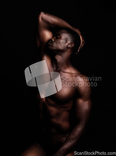 Image of Sensual, nude and black man on dark background with muscular body, natural or dim light. Confident, African American male or strong person shirtless, athletic or bodybuilder with wellness or creative