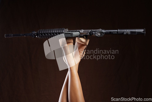 Image of Mafia, criminal and legs of a woman with a gun isolated on a black background in a studio. War, army and feet of a person in heels with a revolver for violence, crime and shooting on a dark backdrop