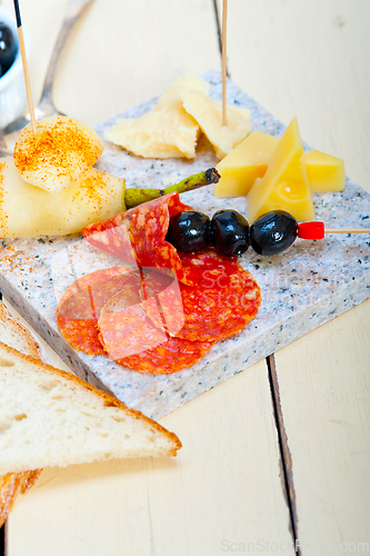 Image of mix cold cut on a stone with fresh pears