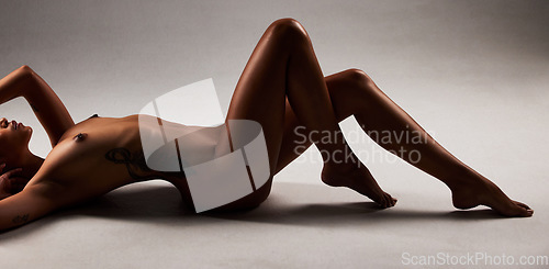 Image of Nude, boobs and sexy naked woman lying on the floor isolated in studio black background. Skin, model and sensual female posing in hot, erotic and beautiful artistic body as a young adult