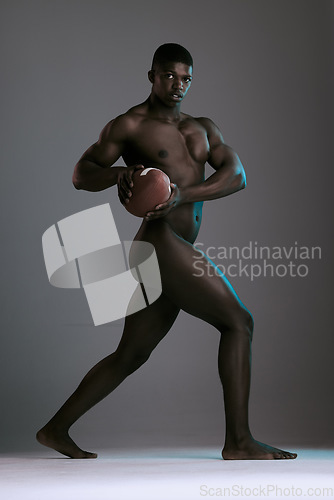 Image of Portrait, nude and body with a model black man holding a football in studio on a gray background for health or sports. Art, muscle and fitness with a handsome young male posing naked for sport