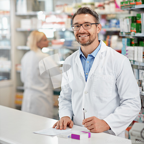 Image of Portrait, service and pharmacist man at counter for medicine help, expert advice and healthcare pharmacy. Retail desk, store and medical professional worker, doctor or person with a friendly smile