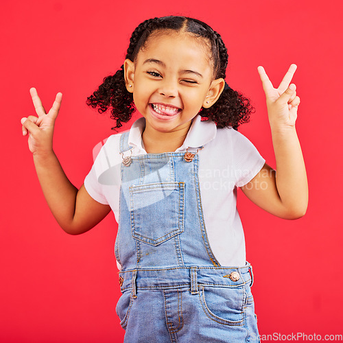 Image of Happy, peace sign and wink with portrait of girl for summer, happiness and funny face. Meme, fashion and smile with child and hand sign for youth, comedy and positive in red background studio