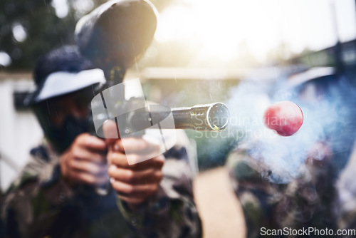 Image of Paintball, gun and ball closeup with person shooting for fun, extreme and sport, fitness and training. Zoom, paintball marker, and target, practice and game with people competing, speed and power