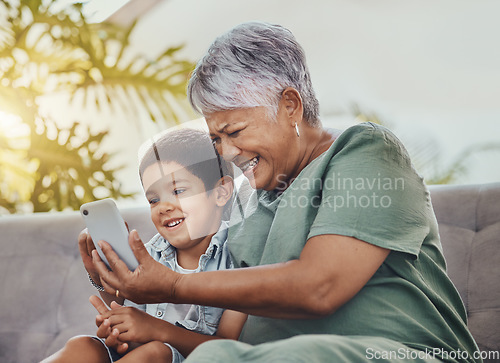Image of Phone, family or grandmother with child for online games, social media meme and funny video for bonding on sofa. Happy, excited and love of senior woman with kid on smartphone for video call or chat