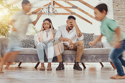 Image of Tired parents, kids running and family in a living room feeling anxiety, headache and stress. Children chaos, run and fatigue of mom and father together on a couch frustrated from parent care