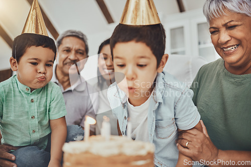 Image of Kids, birthday cake and kid blowing candles at a house at a party with food and celebration. Children, celebrate event and family together in a kitchen with a smile and happiness with parent love