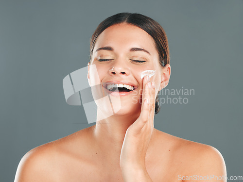 Image of Skincare, beauty cream and woman with happiness from sunscreen and self care in studio. Wellness, spa and smile of a model laugh with collagen lotion with studio background and dermatology treatment