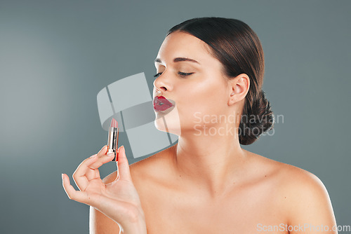 Image of Lipstick, woman and makeup in studio for skincare, cosmetics and aesthetics. Young model face, red colorful lips and beauty product for luxury fashion, salon and cruelty free facial balm application