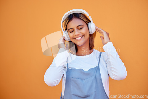 Image of Wall, mockup and woman with headphones, music and relax with confident girl on studio background. Young female, lady and headset for podcast, radio and audio with sounds, streaming and listen to song