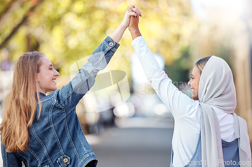 Image of Woman, friends and holding hands walking in the street with smile for holiday weekend or friendship in the outdoors. Happy women taking a walk together smiling in happiness for adventure in nature