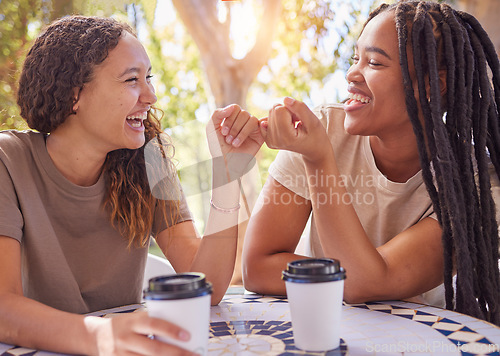 Image of Happy, pinky promise and women friends in nature enjoying coffee, talking and bonding together. Happiness, secret and young female best friends speaking and drinking tea in an outdoor garden or park.