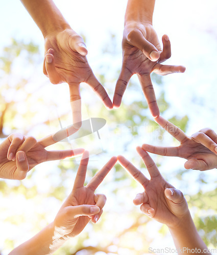 Image of Hands together, star sign and team sun gesture with hand to show group work and community. Outdoor, lens flare and below of people doing teamwork with friends showing commitment and solidarity