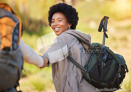 Image of Black woman, holding hands and hiking with smile for travel, adventure or journey with partner in nature. Happy African American female helping friend on hike in support for trekking challenge