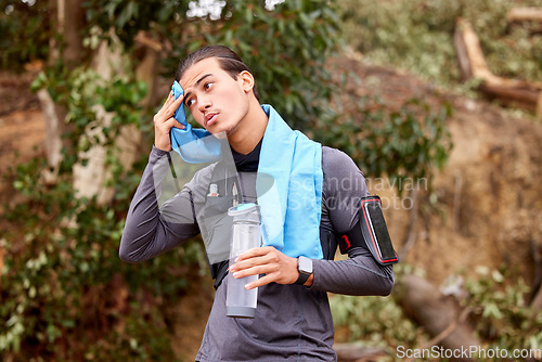 Image of Fitness, sweat and man running on a mountain for exercise or training for a race or marathon. Sports, health and young male athlete or runner taking a break while doing a cardio workout in nature.