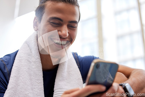 Image of Man relax, fitness and smartphone in gym, smile and rest after workout, training and typing for social media. Male, athlete and guy with cellphone, break and connection for chatting and with towel