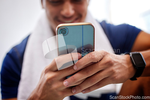 Image of Phone, fitness and social media with a sports man typing a status update to post his workout progress. Mobile, exercise and app with a male athlete tracking his workout while training in a gym