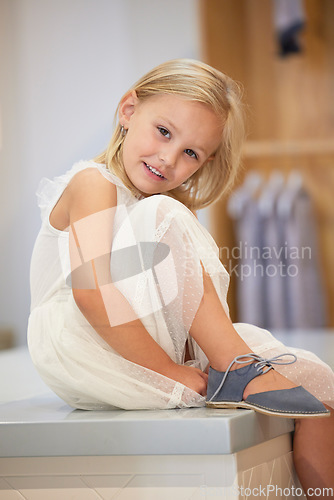 Image of Portrait, children and shoes with a girl customer shopping in a mall or retail store for footwear. Fashion, kids and clothes with a female child trying on a new shoe for trendy style as a shopper