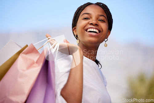 Image of Shopping, black woman and portrait outdoor with retail bags after sale and sales promotion. Happy, smile and excited young person in nature feeling freedom after market deal and fashion mall discount