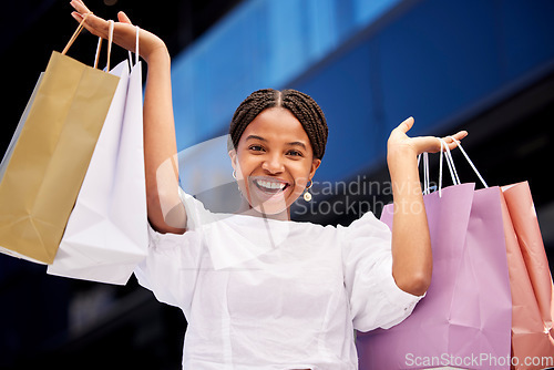 Image of Portrait, shopping and an excited black woman customer carrying bags in a mall for retail or consumerism. Sale, product and fashion with a young female consumer or shopping buying from a store