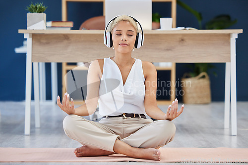 Image of Music, meditation and yoga with a business black woman finding inner peace or zen in her office. Headphones, mental health and balance with a calm female eployee meditating at work for wellness