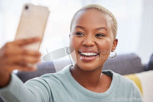 Image of Black woman, influencer and smile for selfie, social media or profile picture relaxing on living room sofa at home. African American female vlogger smiling in happiness for online post in the lounge