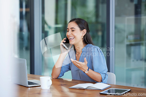 Image of Phone call, communication and laugh with a business woman talking while sitting in her office for work. Laptop, mobile or internet with a female employee working at her desk and laughing at a joke