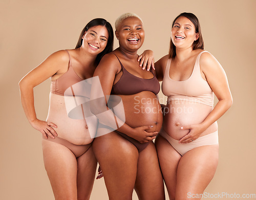 Image of Portrait, beauty and laugh with pregnant friends in studio on a beige background for diversity or motherhood. Family, love and pregnancy with a woman friend group showing their baby bump stomach