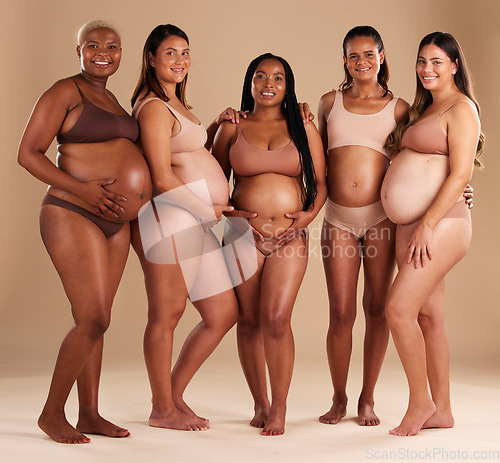 Image of Pregnancy, women and portrait of friends in a studio for diversity, motherhood and prenatal wellness. Maternity, love and pregnant females showing their baby bump stomach together by beige background