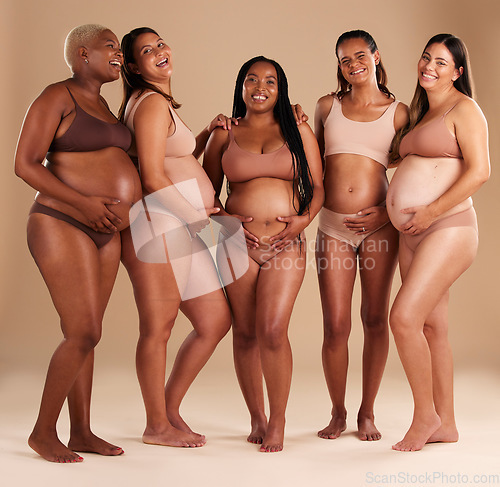 Image of Pregnancy, community and portrait of friends in studio for diversity, motherhood and prenatal wellness. Maternity, love and pregnant women showing their baby bump stomach together by beige background