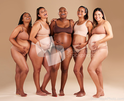 Image of Pregnancy, body and portrait of happy friends in a studio for diversity, motherhood and prenatal wellness. Maternity, beauty and pregnant women showing baby bump stomach together by beige background.