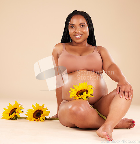 Image of Black woman sitting with flower, pregnant with smile in portrait and beauty, skincare isolated on studio background. Pregnancy glow, mother and nature with natural cosmetic care, health and wellness