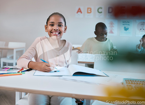 Image of Education, class and portrait of child with smile in classroom learning reading, writing and math in Montessori school. Books, students and happy girl at desk with notebook studying for future exam.