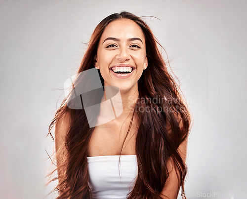 Image of Cosmetics, portrait and woman with hair care, shine and girl with smile on grey studio background. Female, lady and happiness for salon treatment, scalp grooming and routine for volume and texture