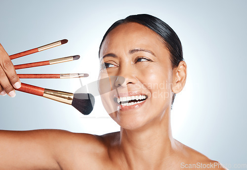 Image of Makeup, skincare and old woman with brushes, foundation and with grey studio background. Mature female, senior lady and cosmetics tools for dermatology, retirement and beauty for soft and clear skin