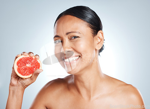 Image of Grapefruit, happy woman and face portrait for beauty on studio background. Skincare model, smile and citrus fruits for natural cosmetics, detox and nutrition benefits for healthy aesthetic results