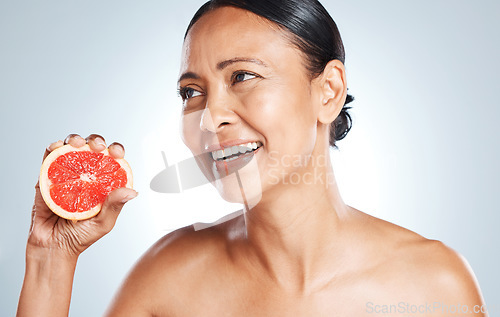 Image of Grapefruit, skincare and woman on studio background for wellness benefits. Beauty model, face and citrus fruits for natural cosmetics, detox and nutrition for healthy aesthetic results, shine or glow