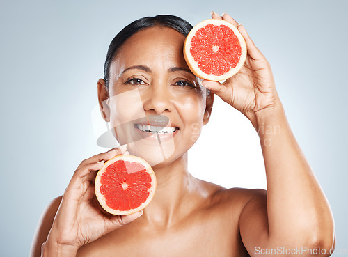 Image of Grapefruit, portrait and vitamin c skincare of happy woman on studio background. Beauty model, face and citrus fruits for natural cosmetics, detox and nutrition benefits for healthy aesthetic results